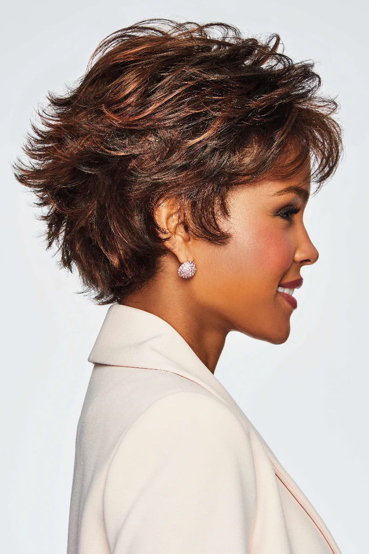 Woman with styled short hair wearing a white outfit against a light background