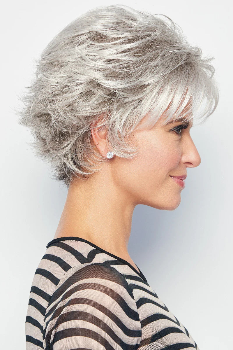 Woman with styled silver hair against a plain background