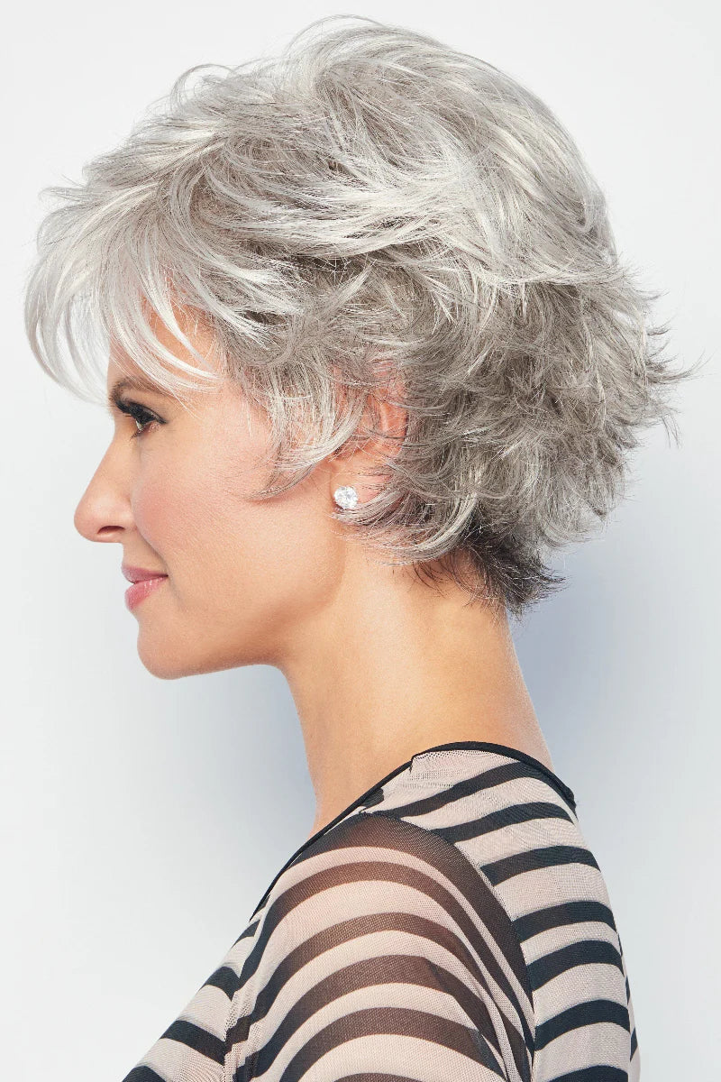 Woman with short, styled gray hair wearing a striped top against a plain background