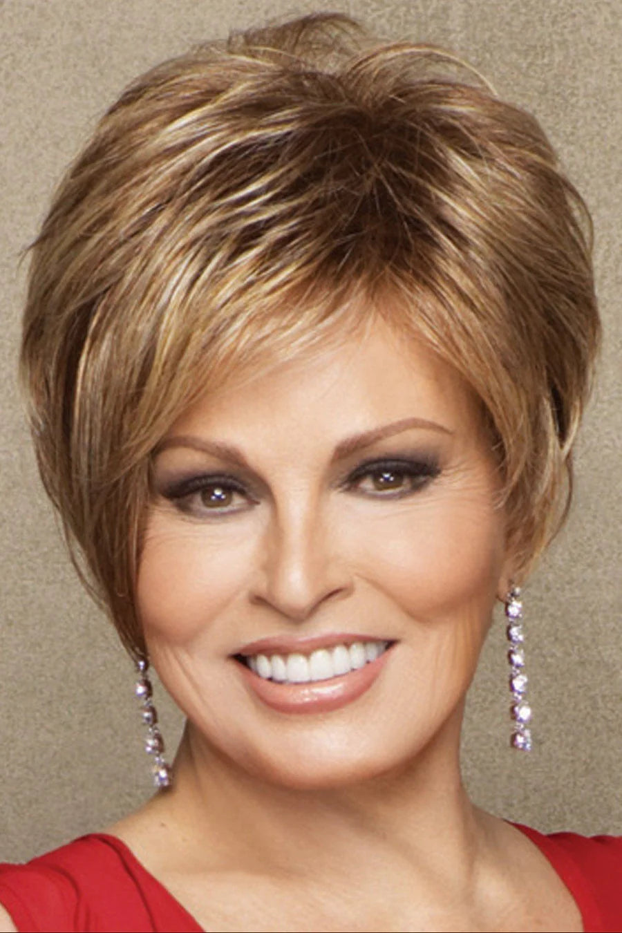 Woman with styled hair and earrings against a neutral background