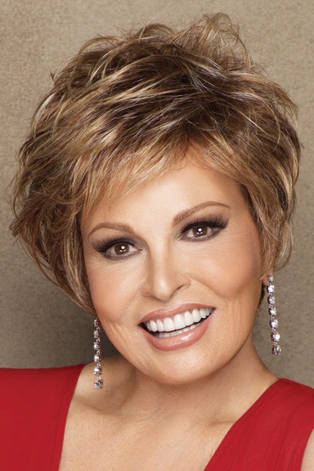 Woman with styled hair wearing a red garment against a neutral background
