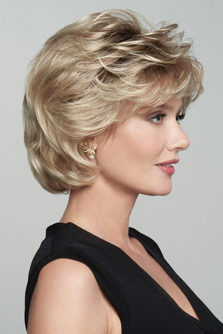 Woman with styled blonde hair against a gray background