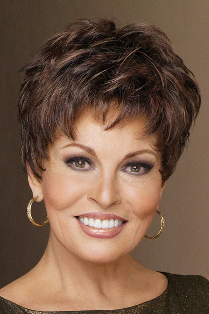 Woman with short brown hair wearing gold hoop earrings against a brown background