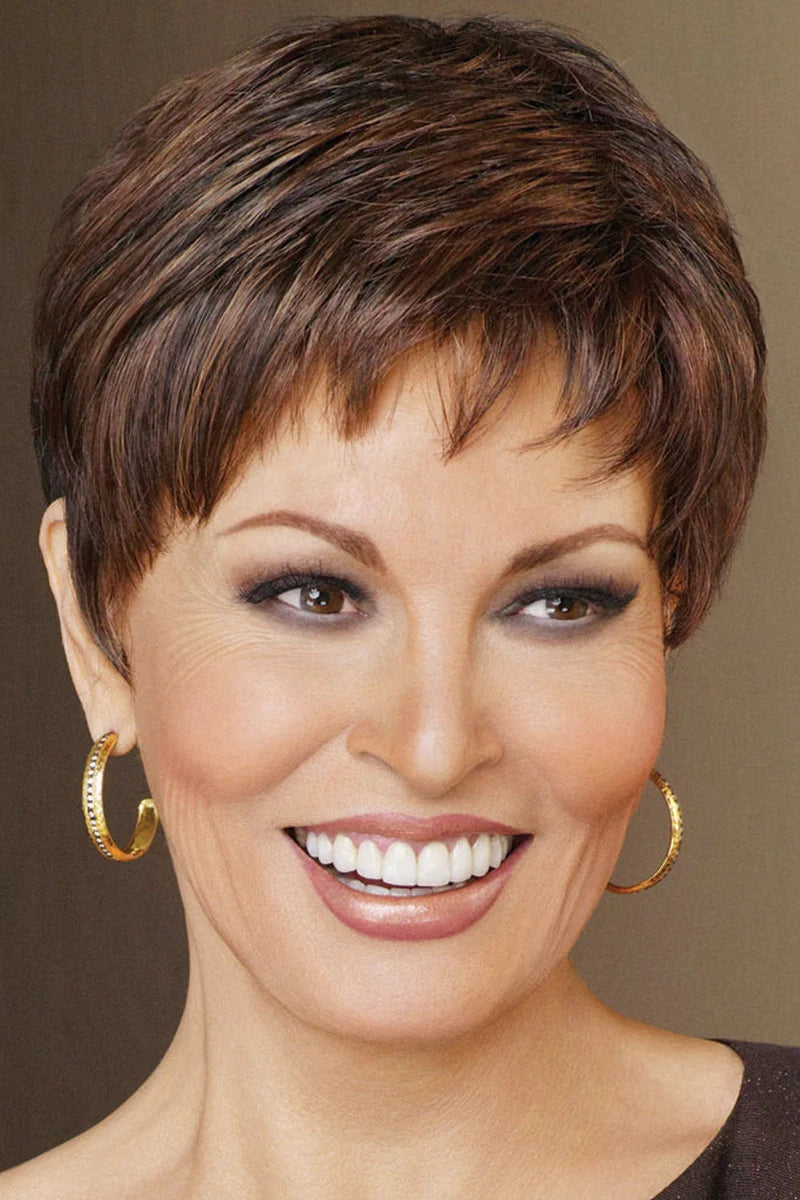 Woman with short brown hair wearing gold hoop earrings against a brown background