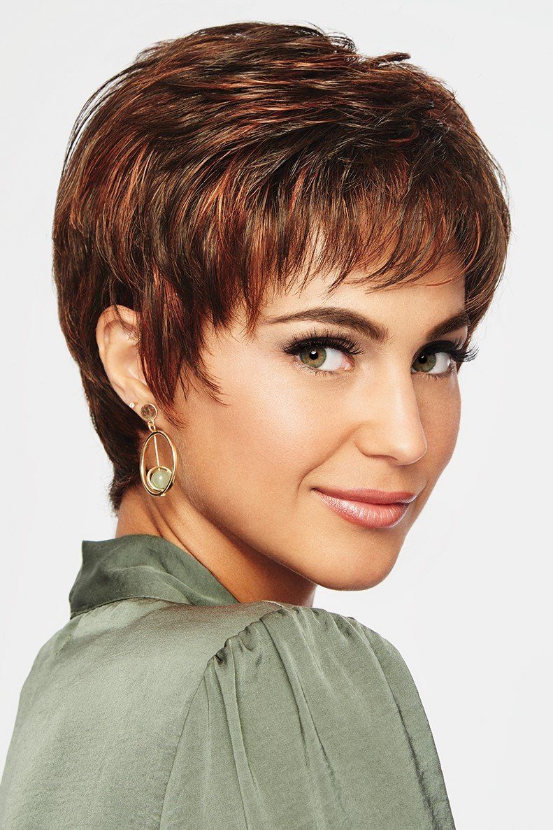 Woman with short brown hair wearing a green top on a white background