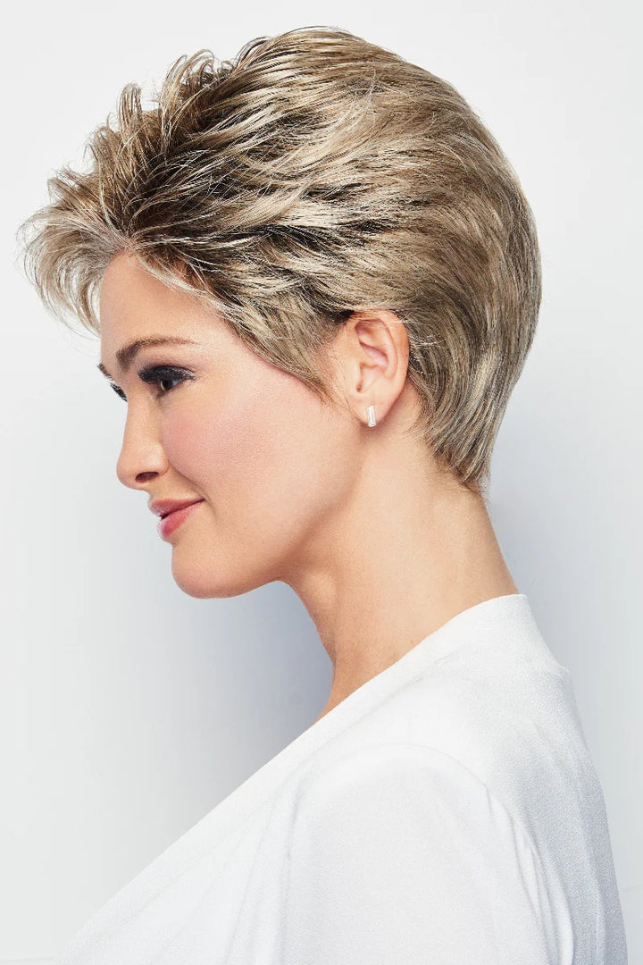 Woman with styled short hair against a plain background