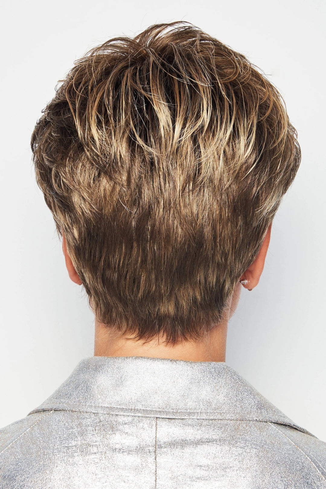 Back view of a person with short, styled hair on a plain background