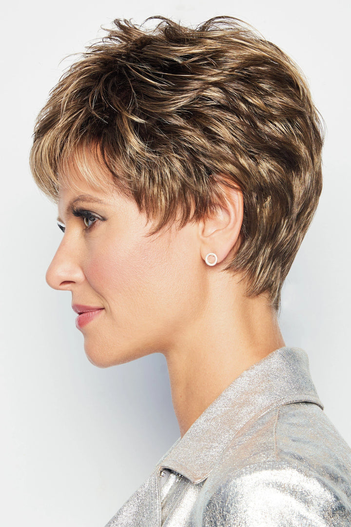 Woman with short, styled hair wearing a silver jacket against a light background