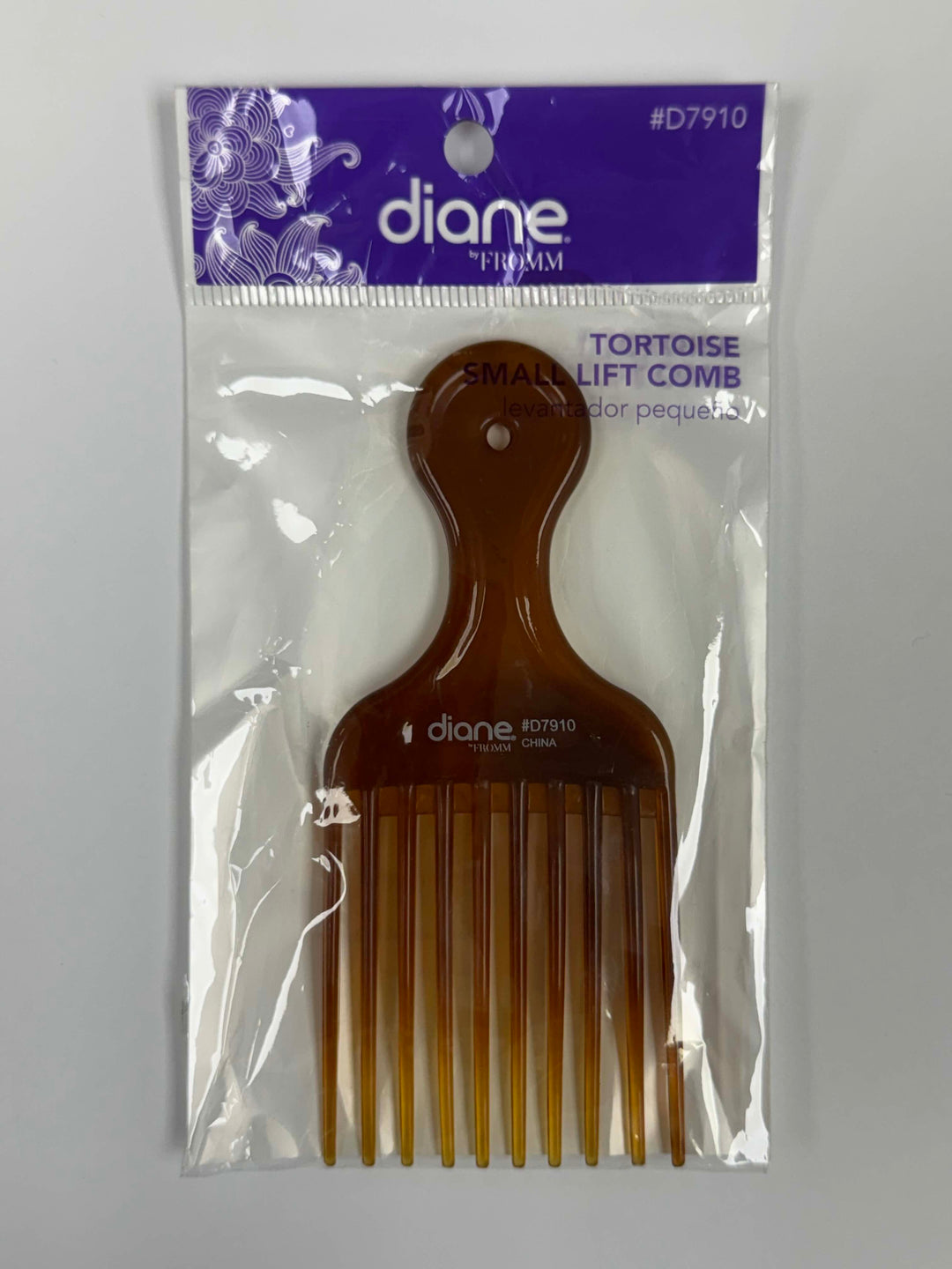A packaged Dionne Fiumi Tortoise Small Lift Comb, featuring a translucent amber-brown hair comb inside a clear plastic bag with a purple header card.