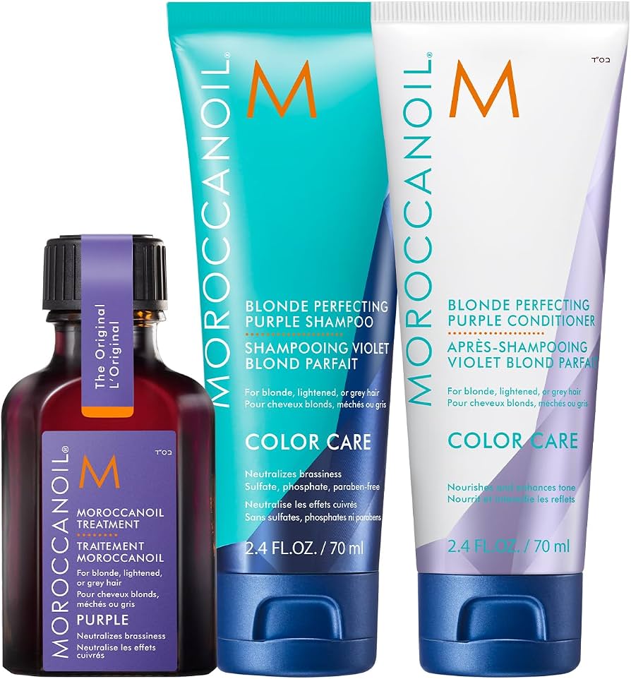 Moroccanoil Color Care blonde perfecting purple shampoo, conditioner, and treatment set. The set includes a dark purple bottle with a black cap and purple label, a turquoise and white shampoo tube, and a white conditioner tube with purple and orange accents, all on a white background.